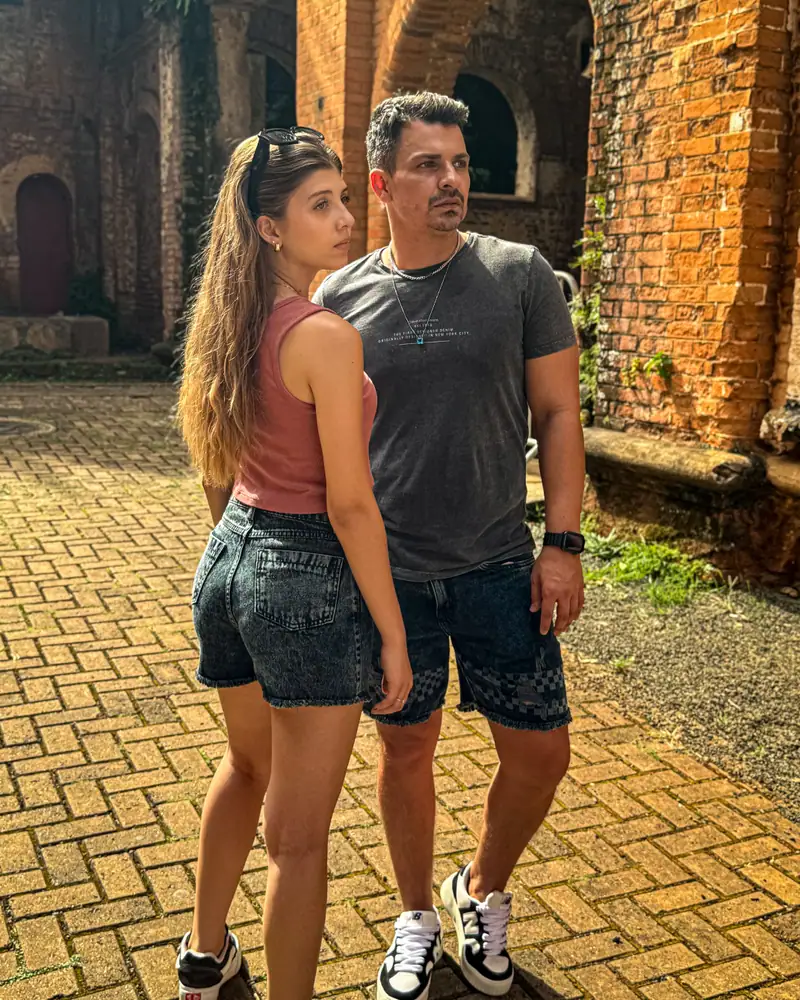 Casal com shorts jeans CVHM em frente a um prédio de tijolos
