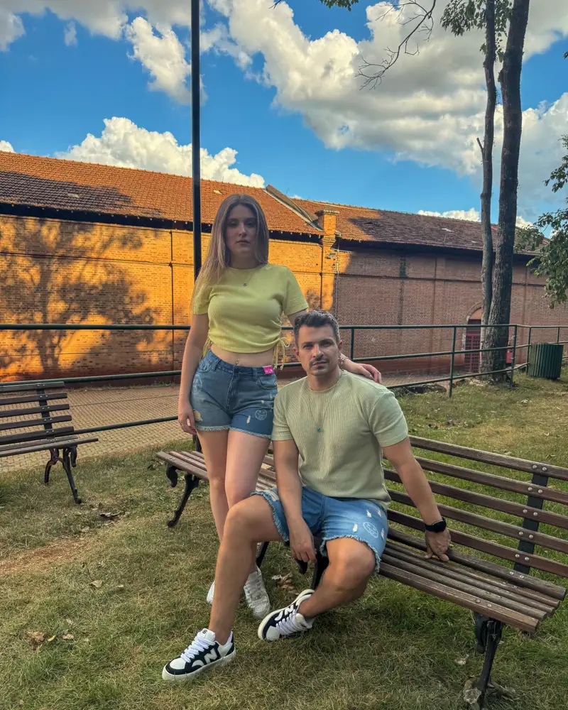 Casal com shorts jeans CVHM sentados em um banco ao ar livre