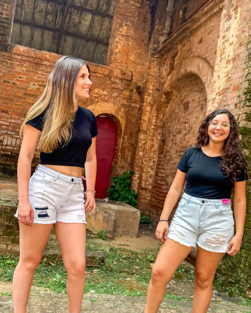 Duas amigas com shorts jeans CVHM em um pátio de tijolos